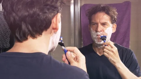Man shaving with razor in front of mirror slow motion  in the morning Stock Footage 119092424