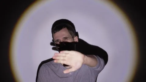 Man shields eyes from blinding bright light with hand Stock Footage 312473360