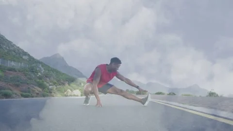 Man shifting weight, sliding into side stretch on mountain road, fog rising Stock Footage 334202555