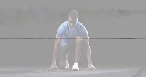 Man shifting weight into sprint start in studio, shoes visible with artifact Stock Footage 332274527