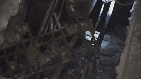 A man shines a lantern into a big hole in the floor Stock Footage 110808084