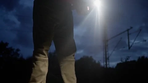 A man with a shining flashlight, bravely exploring beneath an ominous and Stock Footage 319314265