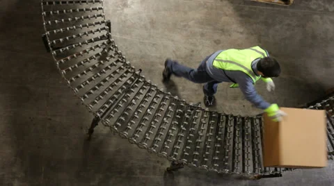 Man in shipping warehouse moves boxes along conveyor Vidéo 32720040