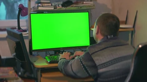 A man in a shirt and pants is watching a monitor screen with a green color Stock Footage 104782553