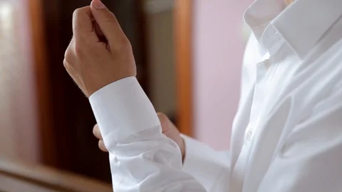 Man in shirt dressing up and adjusting tie on neck at home. Is going to work. Stockbeeldmateriaal 123701560