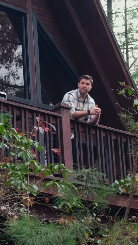 A man in a shirt drinking hot tea from a mug in the morning at the shallet house Stock Footage 295006170