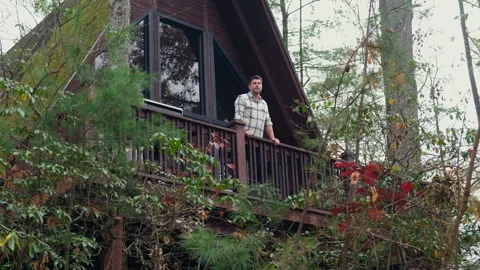 A man in a shirt drinking hot tea from a mug in the morning at the shallet house Stock Footage 295006216