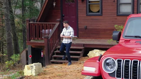 A man in a shirt drinking hot tea from a mug in the morning at the shallet house Stock Footage 295165977