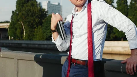 A man in a shirt, a red tie, a notebook standing on the street. Stock Footage 153245035