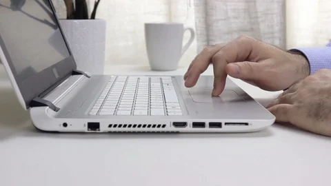 Man in a shirt is using the touchpad on a laptop Stock Footage 128104108