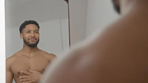Man shirtless in mirror touching chest and adjusting hair while checking fa.. Stock Footage 337440307
