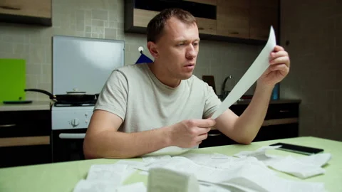 Man in shock, checks commodity checks, considers family budget Stock Footage 132051132