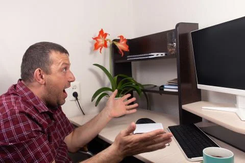 Man in shock, at home at the computer Foto stock