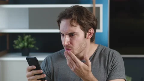 Man is shocked terrible message on his smartphone at home apartment background Vídeos de archivo 142536299