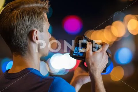 The man shoot with camera by bright lights background Stock Photos