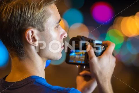 The man shoot with camera by bright lights background Stock Photos