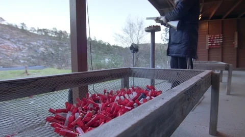 Man on shooting range ejecting shotgun shell into collector Stock Footage 114622086