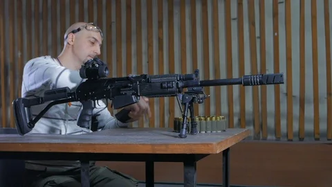 A man in a shooting range loading a carbine of the twelfth caliber Stock Footage 113356170