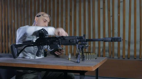 A man in a shooting range loading a carbine of the twelfth caliber and shoots Stock Footage 113356204