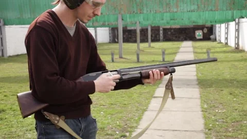 A man shoots a pump-action firearm Stock Footage 151950077