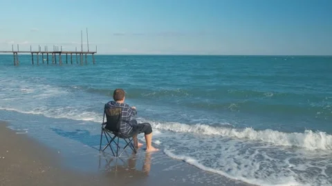 Man shoots video on the beach Stock Footage 168696413