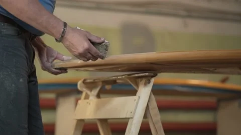 Man in the shop grinds the side of the surf Board Stock Footage 132944267