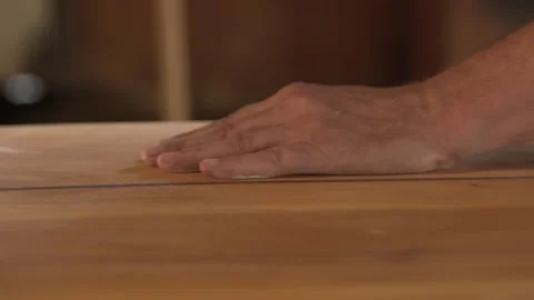Man in the shop grinds the side of the surf Board Stock Footage 132944570