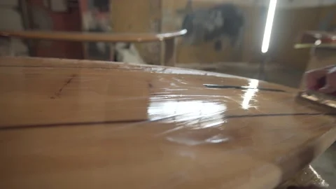 Man in the shop grinds the side of the surf Board Stock Footage 133022898