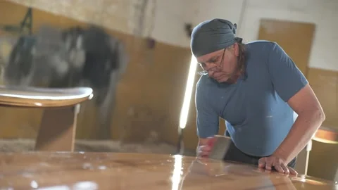 Man in the shop grinds the side of the surf Board Stock Footage 133492929