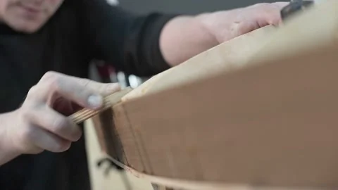 Man in the shop leveled with a knife edge surf Board Stock Footage 132869523