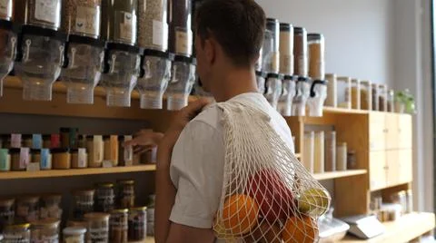 Man in a shop without packaging with pasta, nuts and cereals, vegan products in Stock Photos