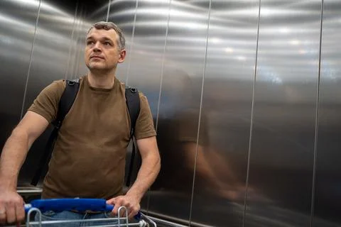 Man with shopping cart in elevator Stock Photos