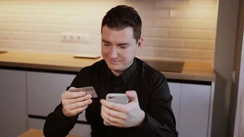 Man shopping with credit card using smartphone at home Stock Footage 149693097