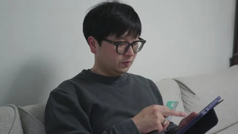 Man shopping on his tablet Stock Footage 259962866