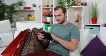 Man Shopping Online from an E-Commerce Website Sit Home Sofa Use Digital Tablet Stock Footage 85544353