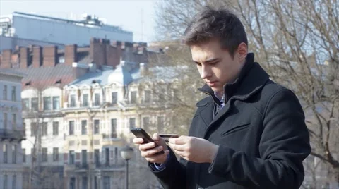 Man shopping online using phone and credit card outside Stock Footage 61864727