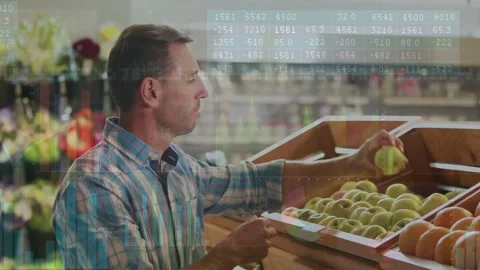 Man shopping retail, reaching crate, inspecting apples while data bars showing Stock Footage 332936945