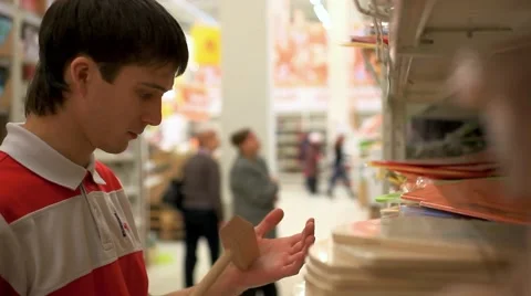 Man with shopping, selects chop hammer in supermarket at Kitchenware. HD Stock-Footage 47478249