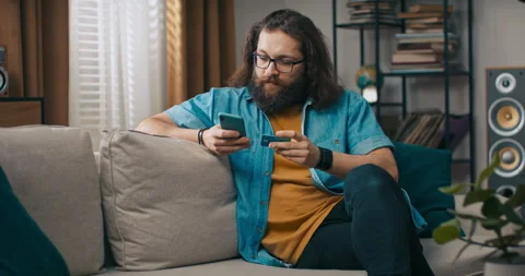 The man shops online with smartphone, orders clothes purchases through the app Stock Footage 218189663