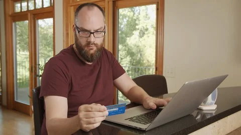 Man shops online using credit card and laptop, buying from home with e-commerce Vídeos de archivo 125407391