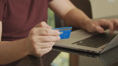 Man shops online using credit card and laptop, buying from home with e-commerce Видео 125407920