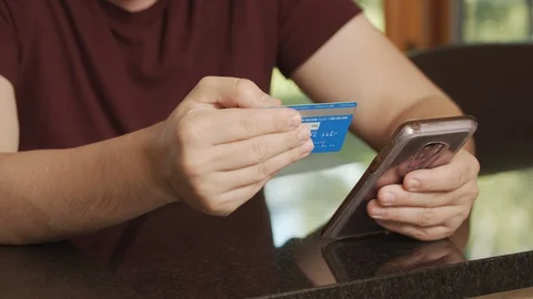 Man shops online using credit card and cell phone, buy from home with e-commerce Stock Footage 127936313