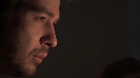 Man with a short beard burning a match in the dark Stock Footage 56958134