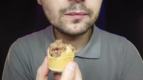 A man with a short beard eats ice cream in a cup, close-up Stock Footage 132093914