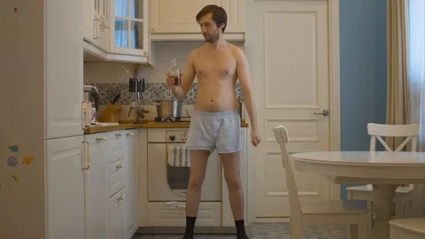 A man in shorts and socks drinking whiskey Stock Footage 129303011