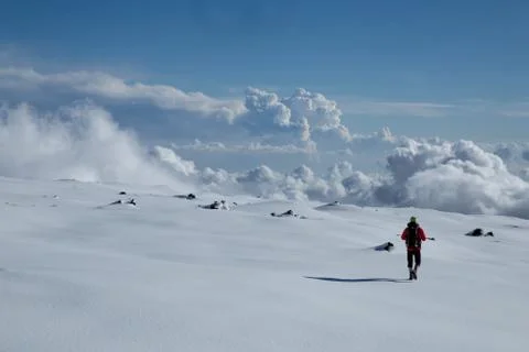 Man in shorts with small backpack walking on a snow leaving no trace Stock Photos