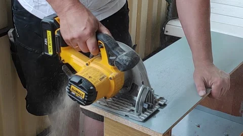 Man in shorts without face,saws old chipboard furniture for recycling on balcony Stock Footage 156573445