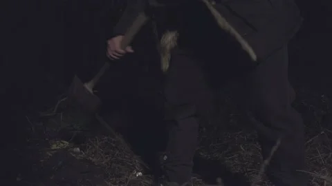 Man with a shovel digging in the forest at night in Birmingham, United Kingdom Stock Footage 220082622