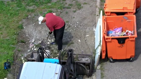 Man with a Shovel Loads Garbage Into a Tractor Tank Stock Footage 194677705