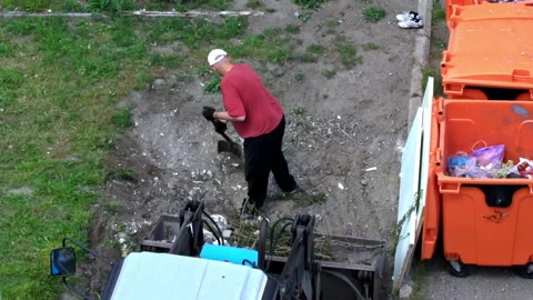 Man with a Shovel Loads Garbage Into a Tractor Tank Stock Footage 197515200